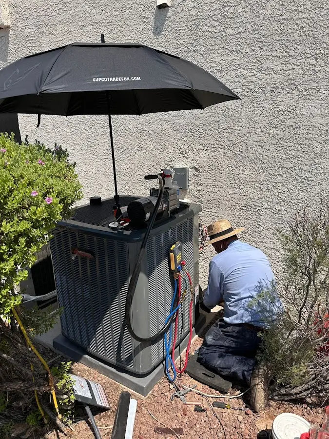 HVAC technician performing outdoor AC maintenance in East Haven